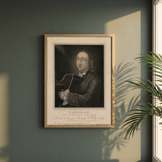 Turlough O’Carolan framed print in a natural oak frame on a dark green wall beside a window, dappled plant shadow
