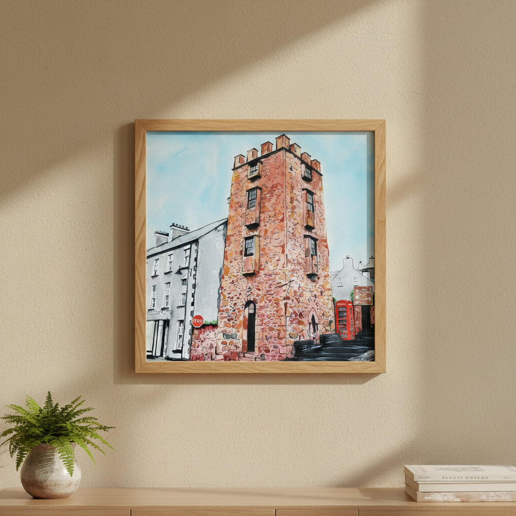 30×30 cm natural oak-framed art print of The Curfew Tower Cushendall hanging in a warm Scandinavian-Irish interior, textured wall, earthy tones, greenery accents, premium lifestyle décor photo with focus on wood grain and matte print texture.