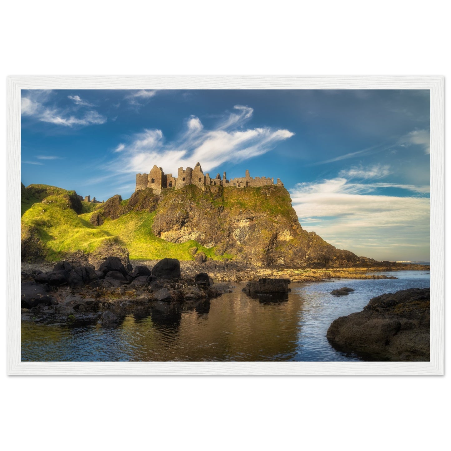 Framed wall art print of Dunluce Castle, showcasing its majestic ruins perched on a rugged cliff overlooking the sea. The detailed image captures the historic architecture and breathtaking coastal scenery, perfect for adding a touch of history and beauty to any room.