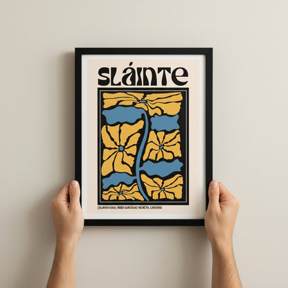 Hands holding the Sláinte print upright against a neutral wall. Clean lifestyle scale reference.
