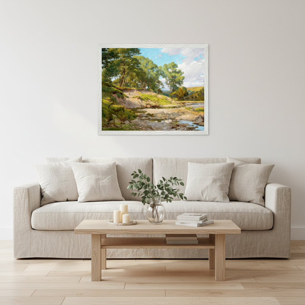 Framed Irish landscape print in a bright living room with white walls, soft linen sofa, light wood flooring, feminine airy interior design, candles and greenery.