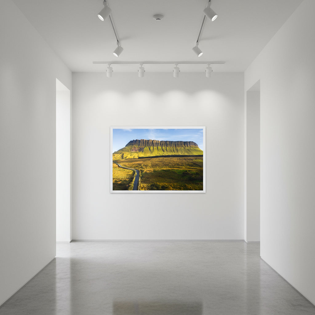 White-framed Benbulben print displayed on a gallery-white wall in a minimalist hallway with spotlight lighting and polished concrete floors.