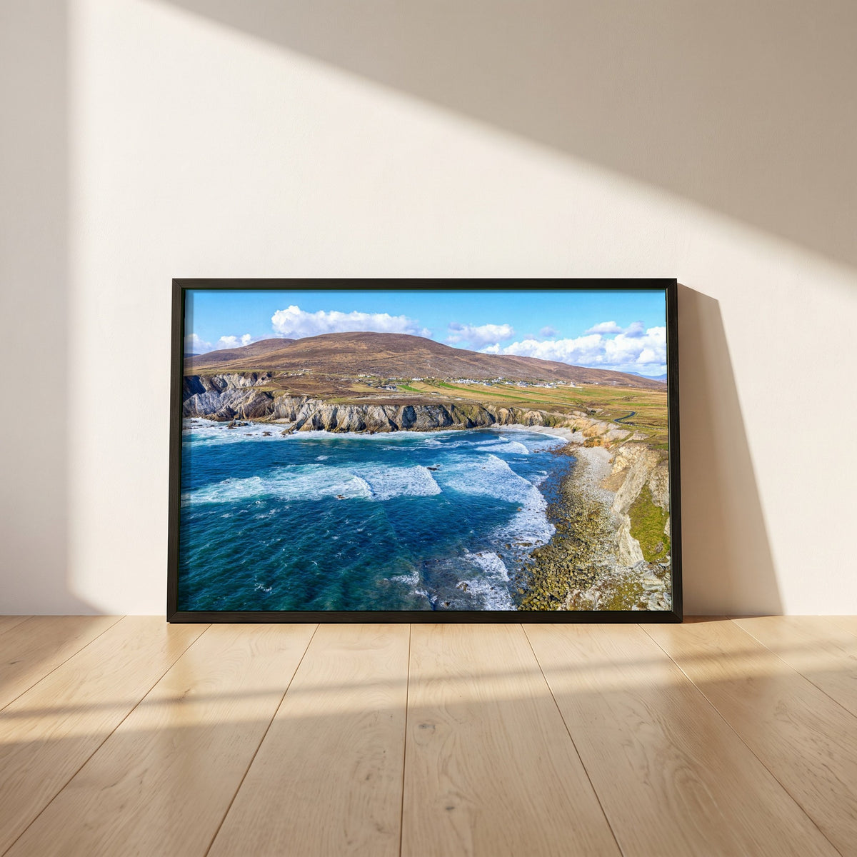 Achill Island Framed Print | Wild Atlantic Way, Co. Mayo framed print in a black frame leaning against a white plaster wall on oak floorboards in morning light