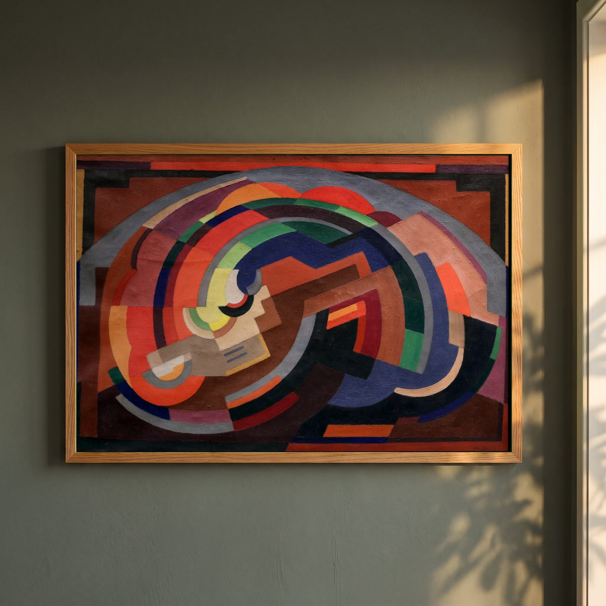 A Composition framed print in a natural oak frame on a dark green wall beside a window, dappled plant shadow