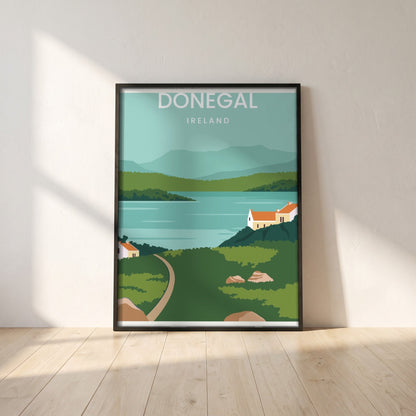 Donegal minimalist travel print in a black frame leaning against a white plaster wall on oak floorboards in morning light