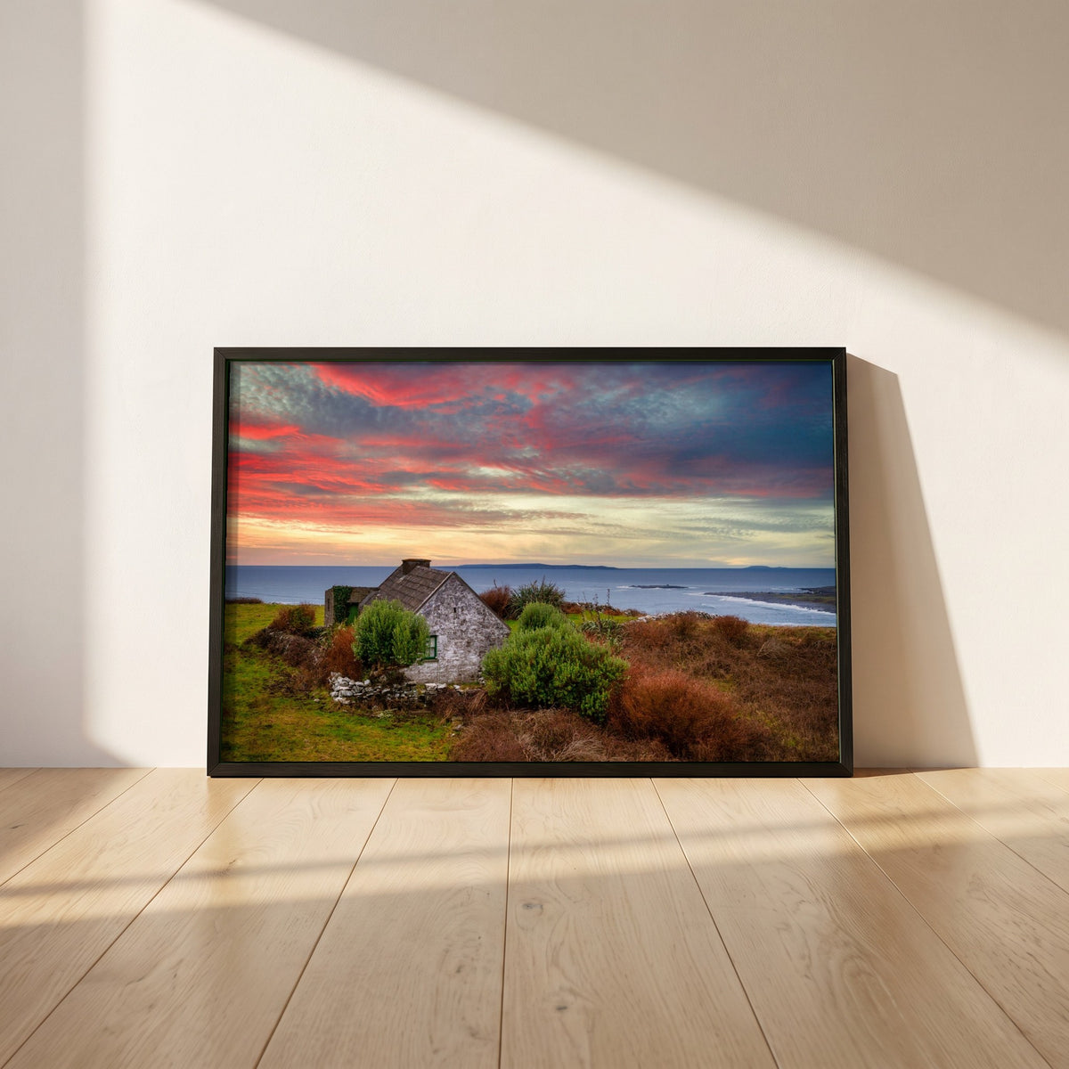 Doolin, Co. Clare framed print in a black frame leaning against a white plaster wall on oak floorboards in morning light