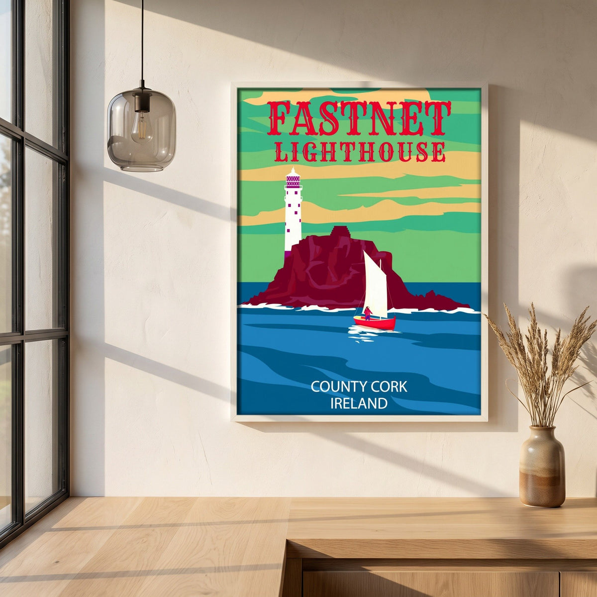 Fastnet Lighthouse retro travel poster framed print in a white frame on a plaster wall above an oak worktop in a bright Scandinavian kitchen