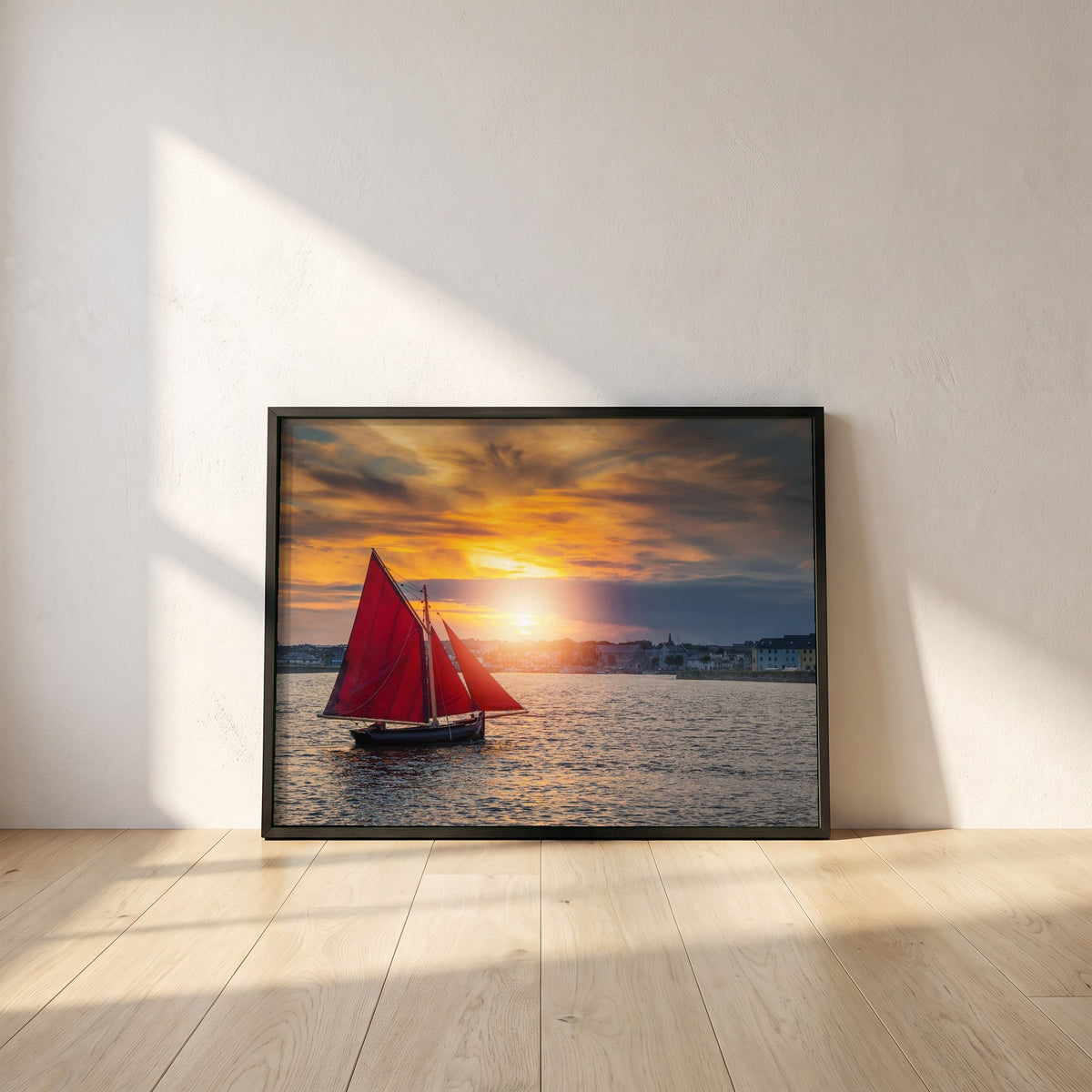 Galway Hooker framed print in a black frame leaning against a white plaster wall on oak floorboards in morning light