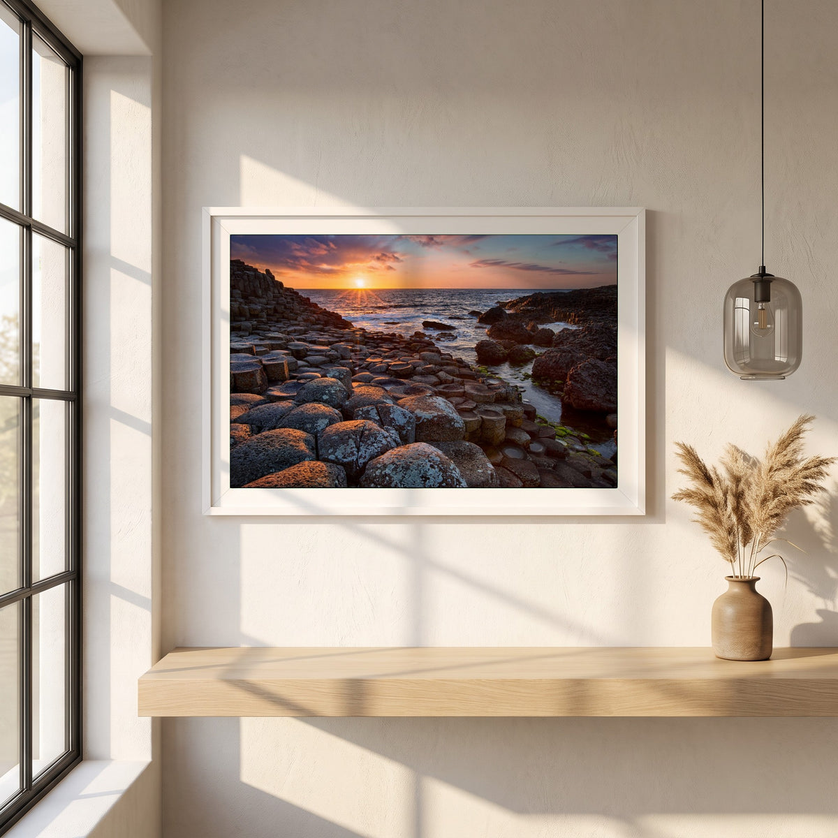 Giant's Causeway framed print in a white frame on a plaster wall above an oak worktop in a bright Scandinavian kitchen
