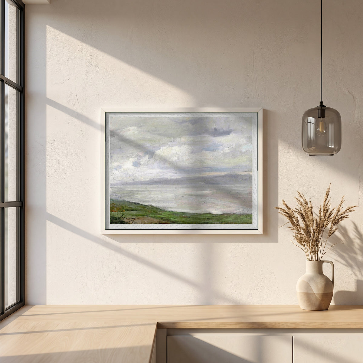 Island Magee framed print in a white frame on a plaster wall above an oak worktop in a bright Scandinavian kitchen