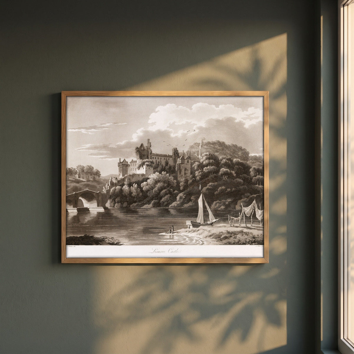 Lismore Castle by Thomas Sautelle Roberts Art Print framed print in a natural oak frame on a dark green wall beside a window, dappled plant shadow