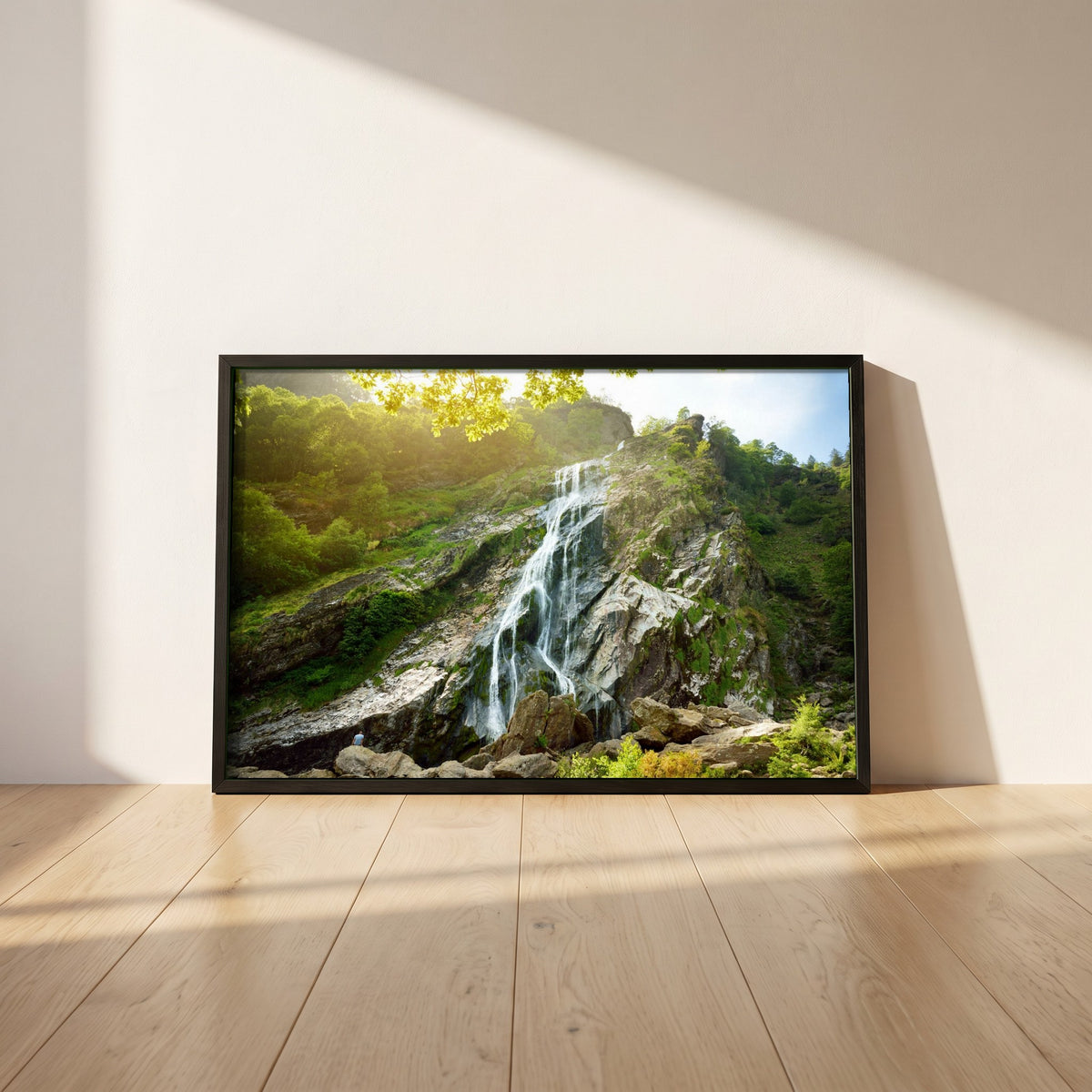 Powerscourt Waterfall Wicklow framed print in a black frame leaning against a white plaster wall on oak floorboards in morning light