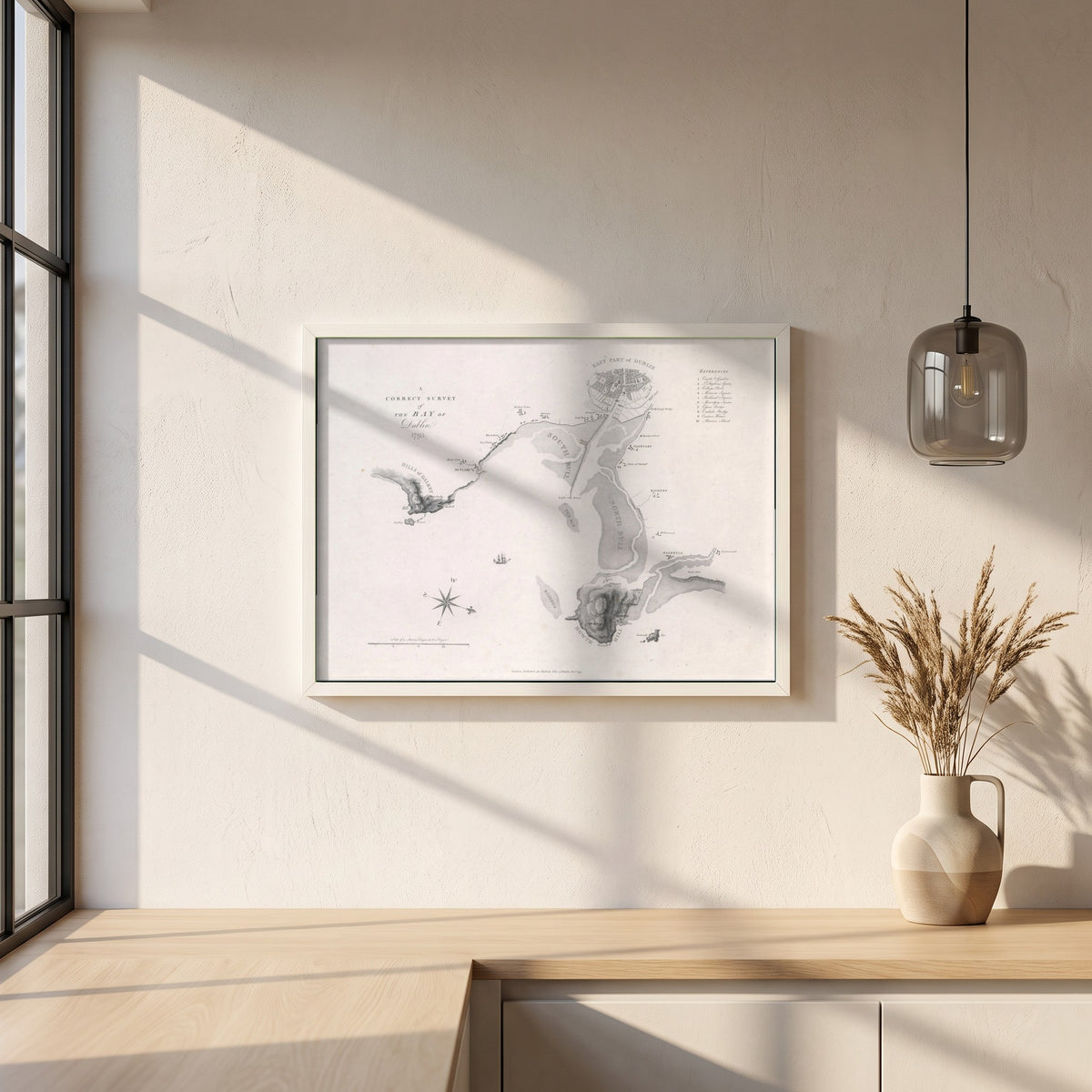 A Correct Survey of the Bay of Dublin, 1795 framed print in a white frame on a plaster wall above an oak worktop in a bright Scandinavian kitchen