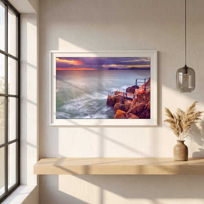 Vico Swimming Dalkey framed print in a white frame on a plaster wall above an oak worktop in a bright Scandinavian kitchen